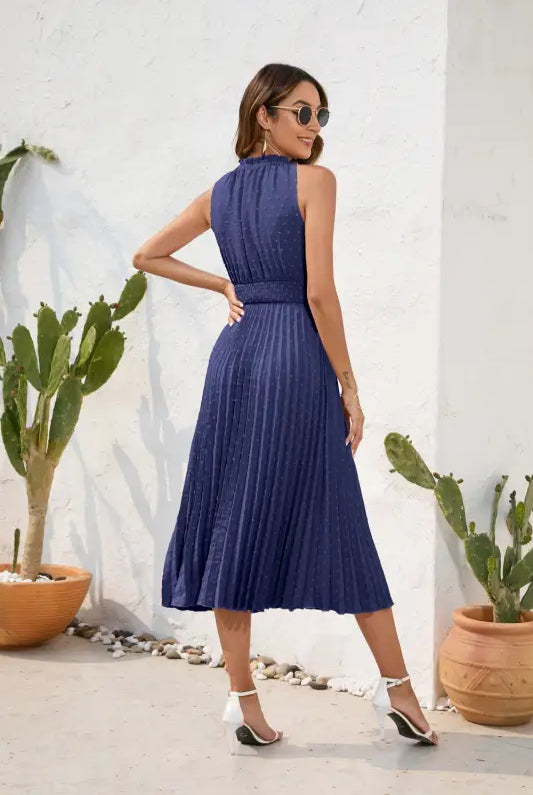 Woman in navy pleated maxi dress, a perfect vacation dress for summer weers