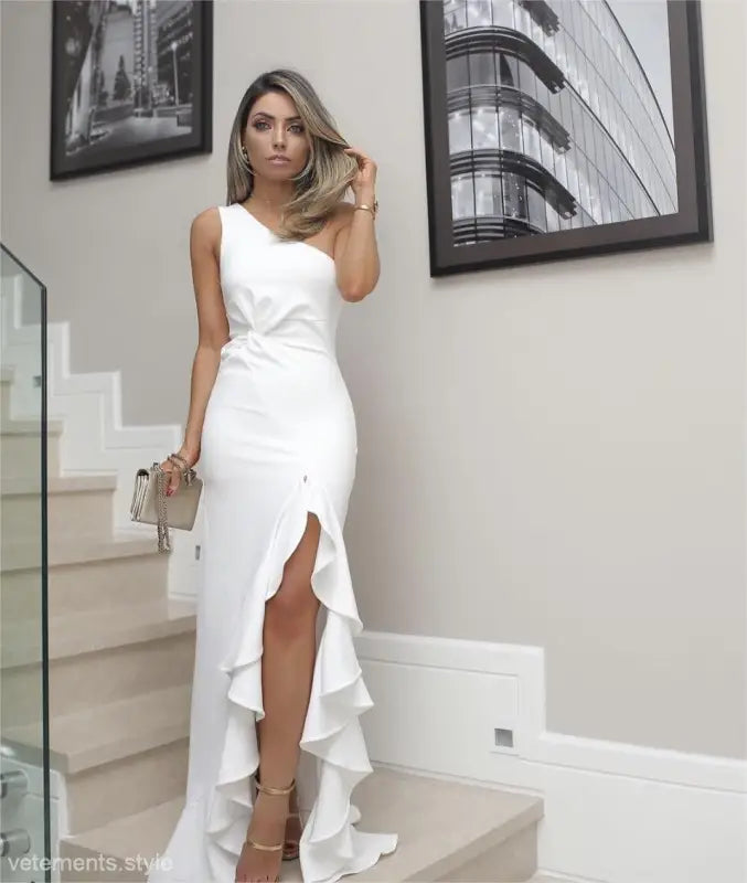 Elegant white one-shoulder gown featuring an elegant ruffled slit and asymmetric design