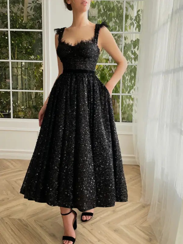 Elegant sequined midi dress with square neckline, delicate straps, and full skirt with pockets