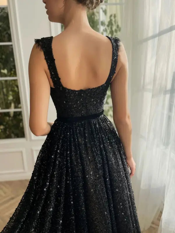 Elegant sequined midi dress in lace and tulle worn by a woman from behind