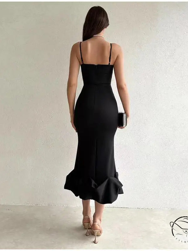 Black form-fitting evening dress with spaghetti straps and a ruffled mermaid-style hem.