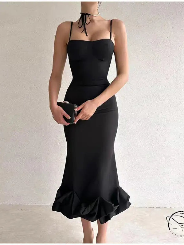 Elegant black mermaid-style dress with spaghetti straps and a ruffled hem.
