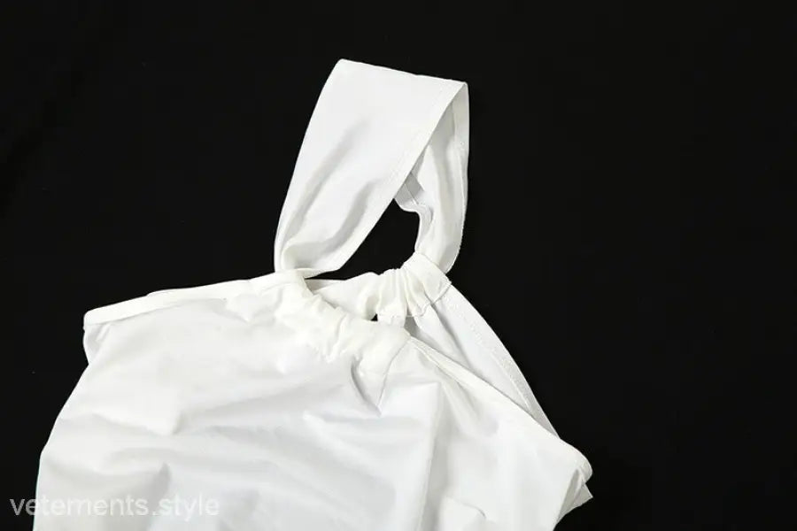 White drawstring bag complementing elegant oblique shoulder backless fit hip dress