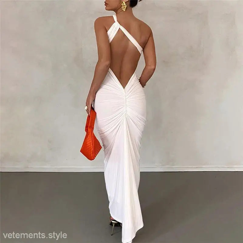 Backless white draped gown featuring a sexy oblique shoulder and fit hip design