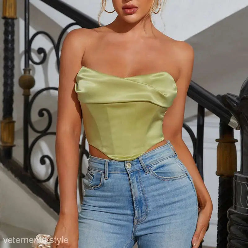 Woman in lime green strapless top and high-waisted jeans showcasing sexy pile boning corset