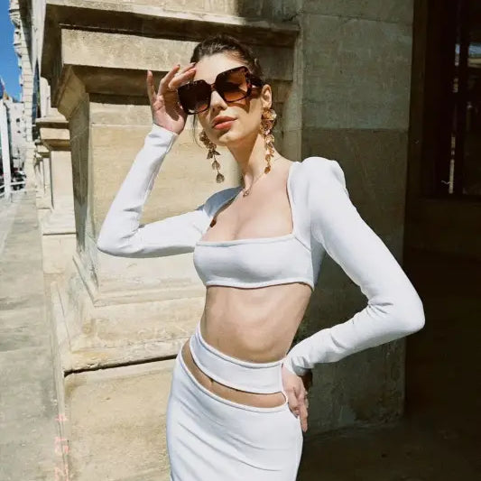 Elegant figure in a white cropped outfit showcasing a sexy stretch bandage dress