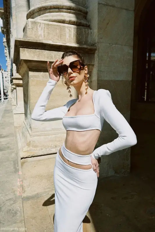 Elegant figure in a white cropped outfit showcasing a sexy stretch bandage dress