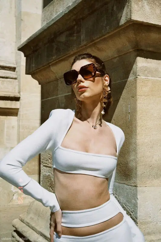 Fashion model in stylish high-end cropped outfit featuring a white stretch bandage dress