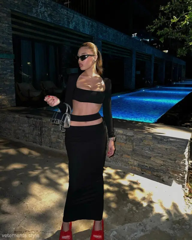 Person in a stylish black stretch bandage dress with cutout design and red heels