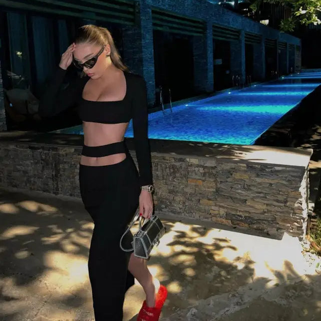 Person in black two-piece athletic outfit by pool, showcasing sexy stretch bandage style