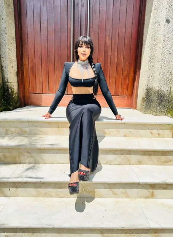 Person in a black crop top and pants showcasing a sexy stretch bandage dress design