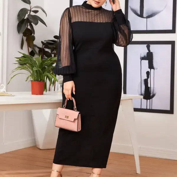 Elegant black long-sleeved dress with sheer upper bodice and sleeves, paired with a pink handbag and nude sandals.