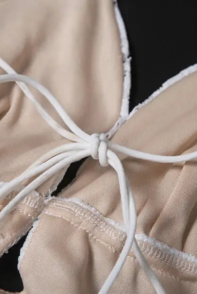 Lace-trimmed beige elegant slim fit evening dress with white tie and backless V-neck design