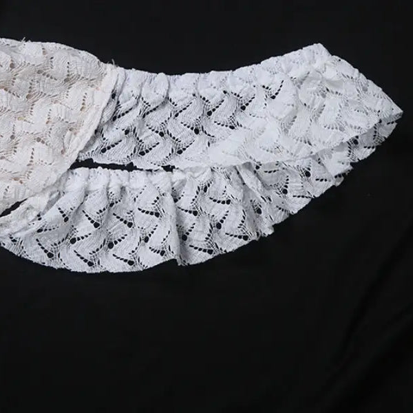 White lace garment with ruffles from an elegant slim fit evening dress collection