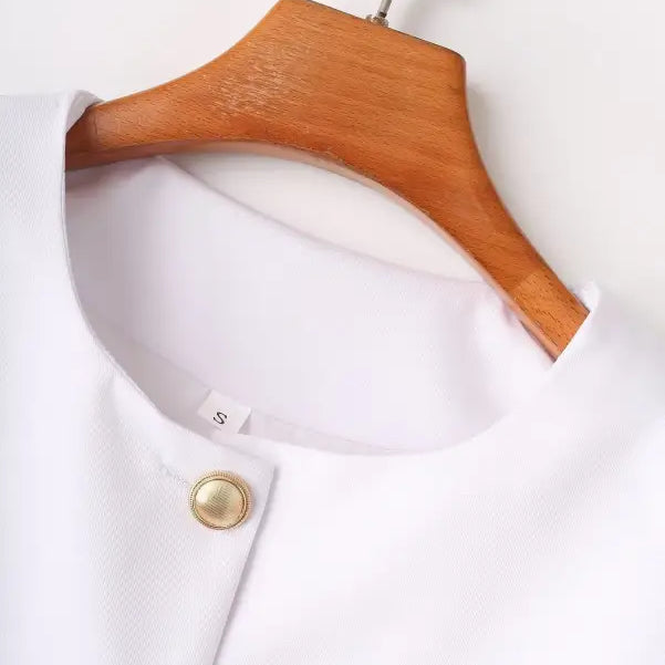 White blouse on wooden hanger, complementing the Elegant Snow White Blazer for Spring and Fall Wear