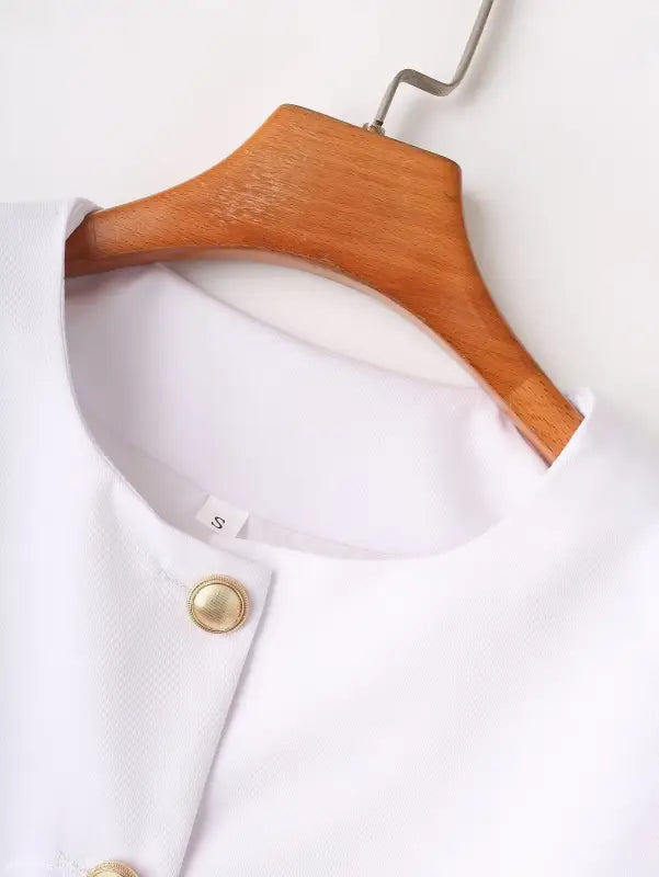 White blouse on wooden hanger, complementing the Elegant Snow White Blazer for Spring and Fall Wear