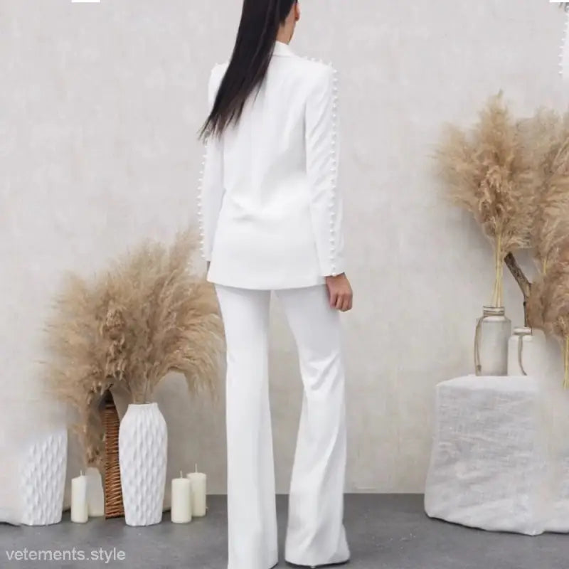 Woman in an Elegant Socialite Pearl Beaded Pantsuit with Tailored Blazer and Flared Trousers