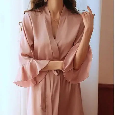 Pink silk robe with ruffled sleeves worn by woman with wavy hair and red lipstick