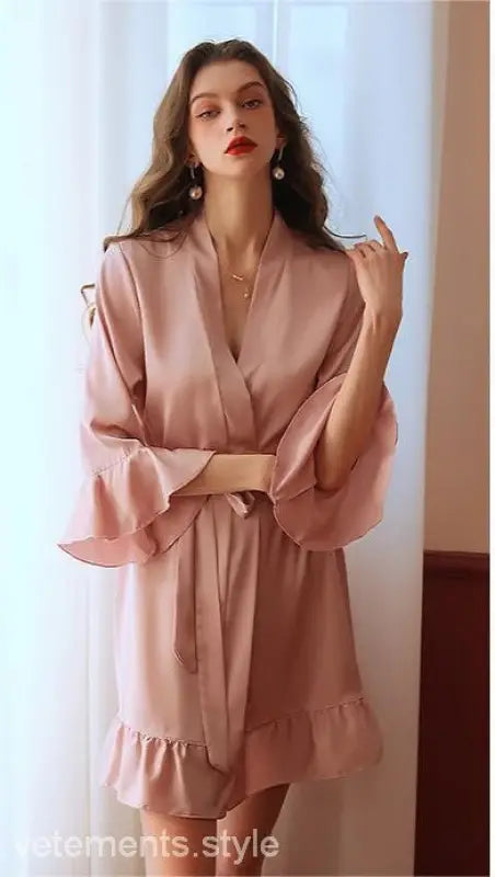 Pink silk robe with ruffled sleeves worn by woman with wavy hair and red lipstick
