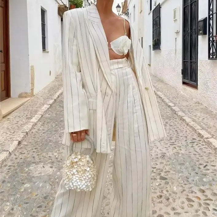 Elegant striped suit pants with spring work blazer and floral handbag, ideal for formal occasions