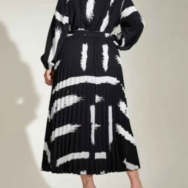 Long-sleeved black and white pleated Elegant Tala Dress with abstract pattern and tie waist