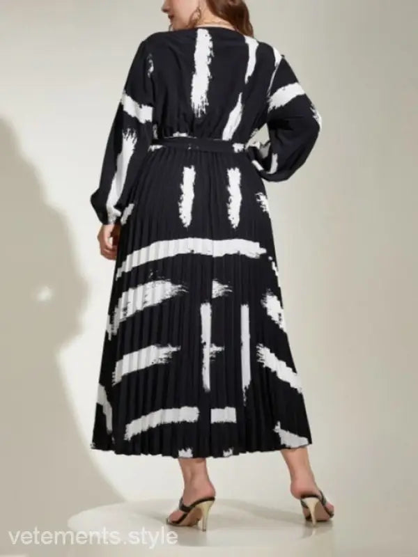 Long-sleeved black and white pleated Elegant Tala Dress with abstract pattern and tie waist