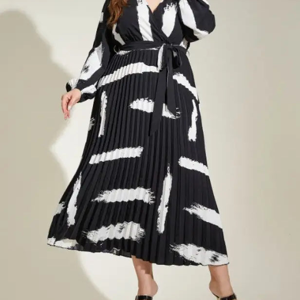 Elegant Tala Dress features a black and white pleated maxi design with an abstract pattern