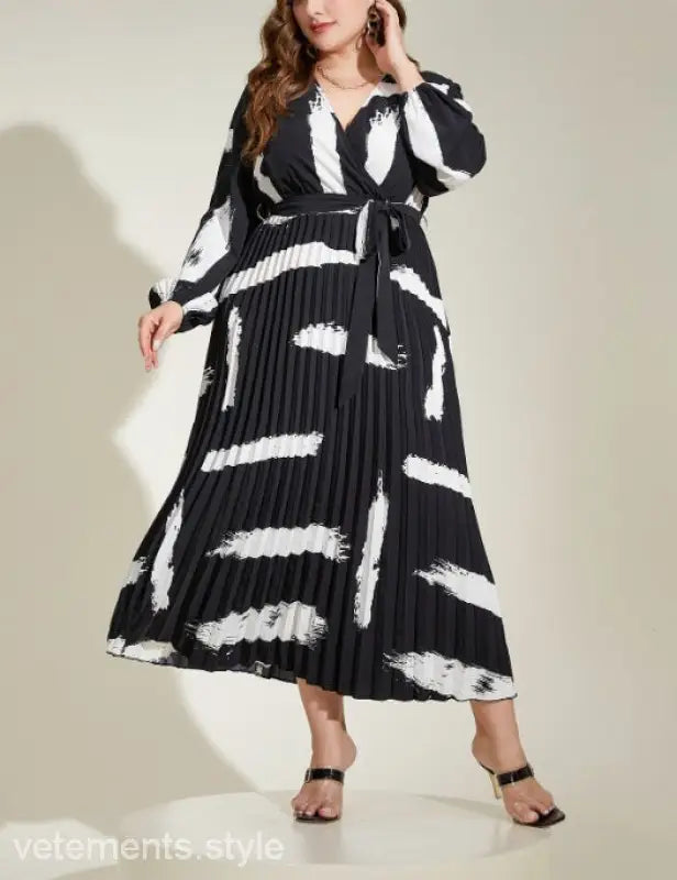 Elegant Tala Dress features a black and white pleated maxi design with an abstract pattern