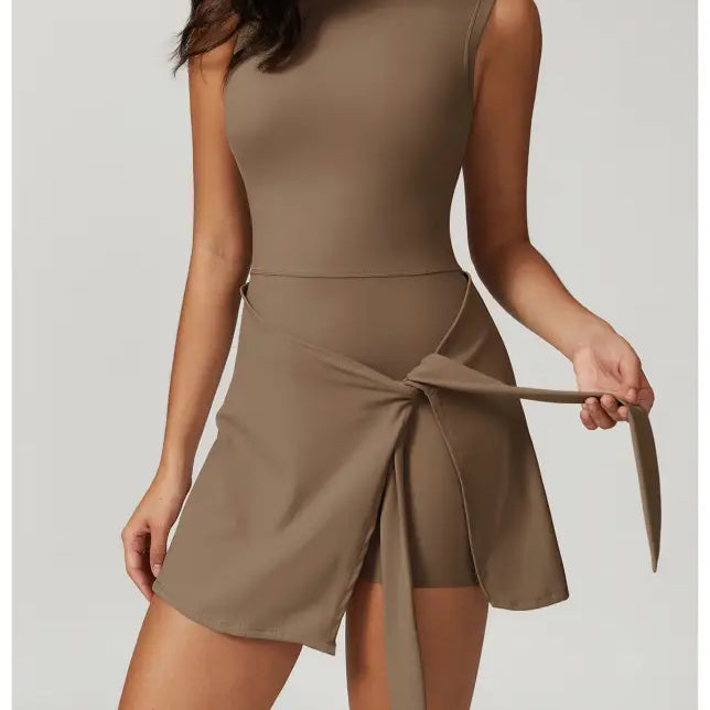 Sleeveless taupe mini dress with a wrap-style skirt and tie detail.