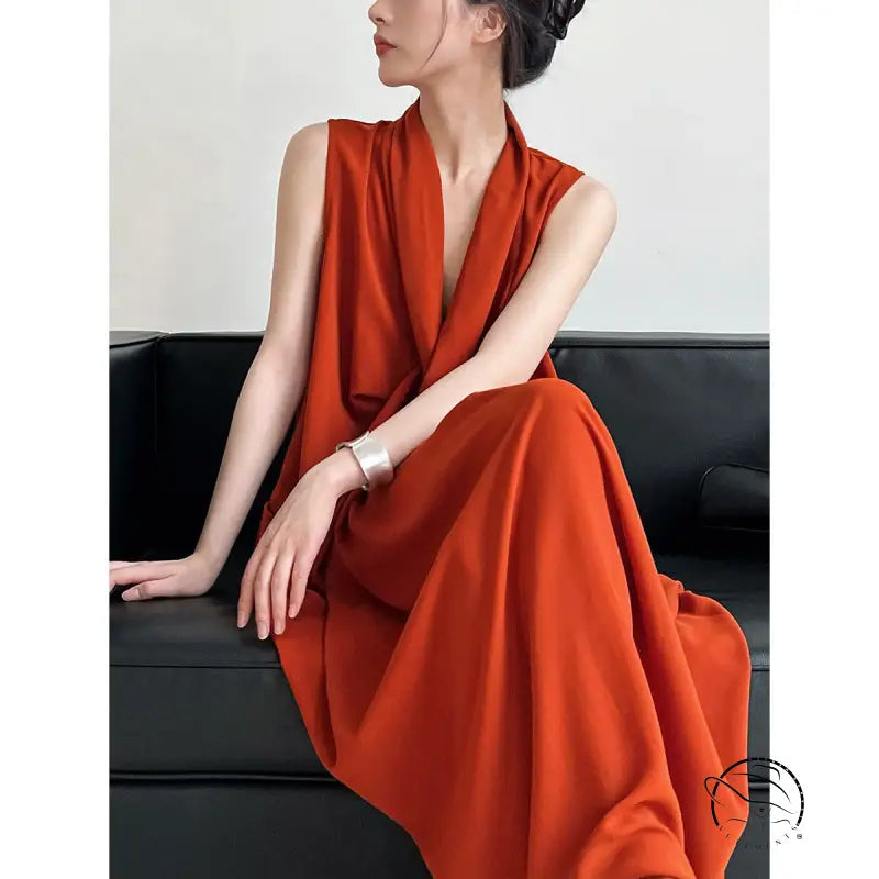 Woman in elegant v-neck long dress with pockets on dark couch