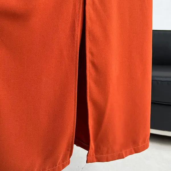 Bright orange pants or trousers with a side slit detail.