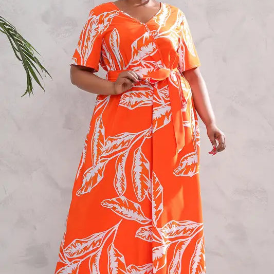 Vibrant orange maxi dress with white leaf print and short sleeves.