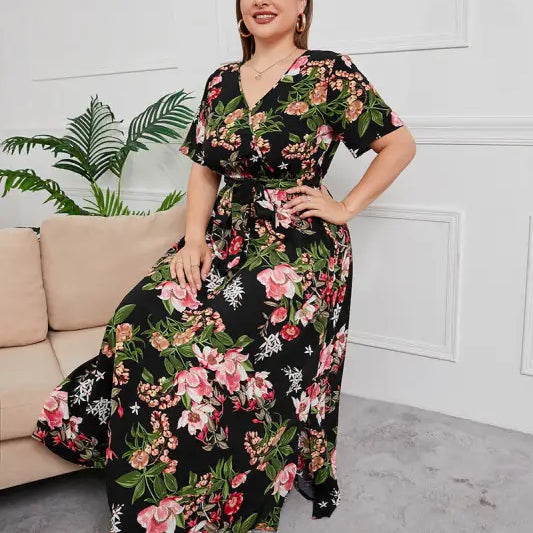 Floral maxi dress with a black background and vibrant pink and green floral print.