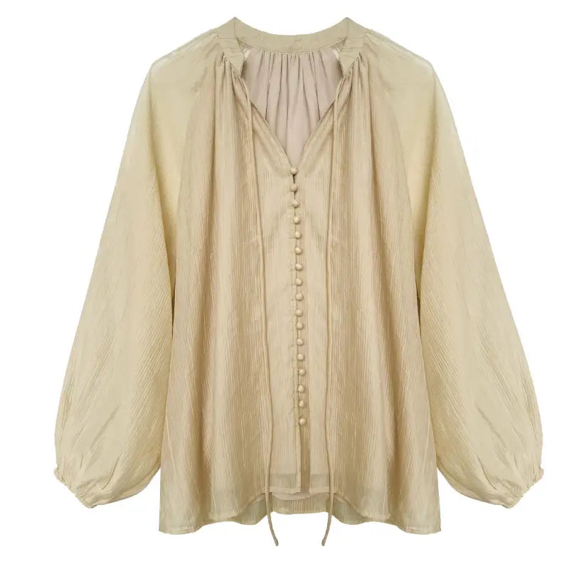 Beige button-down blouse with long sleeves, ideal for versatile wear with wide leg shorts