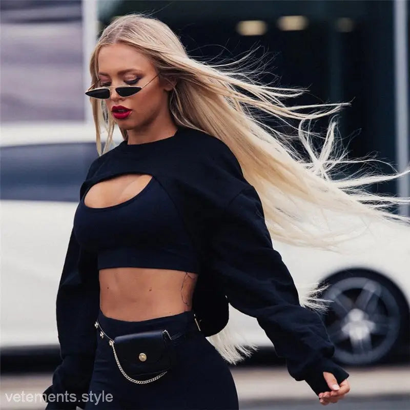 Blonde woman in sunglasses wearing a fashionable fringes sweater with asymmetric solid color design