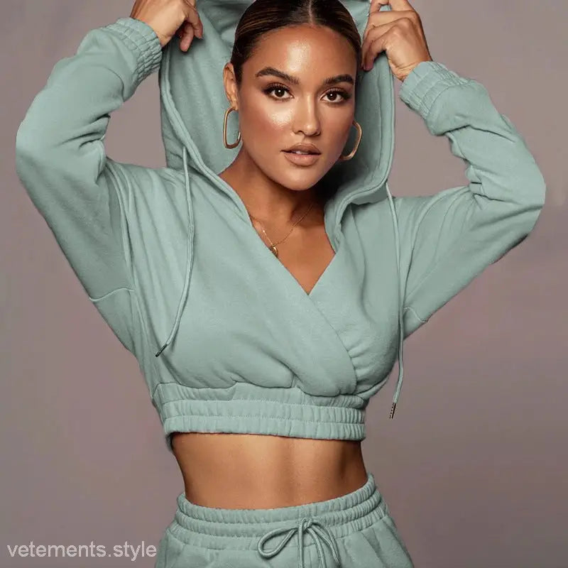 Woman wearing a mint green fashionable sweater suit with open v trousers for spring fall