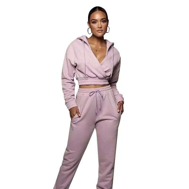 Woman wearing a fashionable sweater suit with open V trousers in soft pink for spring fall