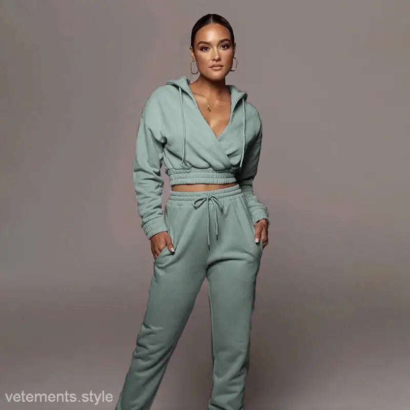 Woman wearing a mint green fashionable sweater suit with fitted open V trousers for Spring/Fall