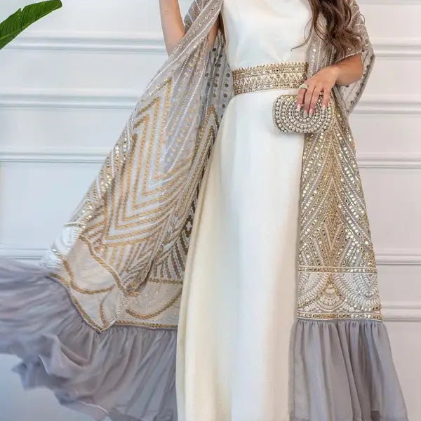 Elegant white gown with gold-embellished cape and belt, ideal for fashionable urban casual style
