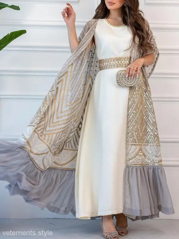 Elegant white gown with gold-embellished cape and belt, ideal for fashionable urban casual style