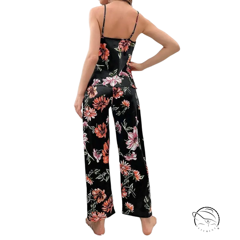 Woman in floral silk homewear jumpsuit with spaghetti straps and wide-leg pants, viewed from behind
