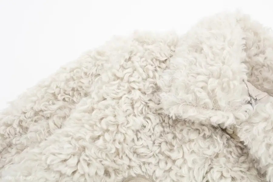 Textured off-white faux fur garment showcased as a winter furry short jacket