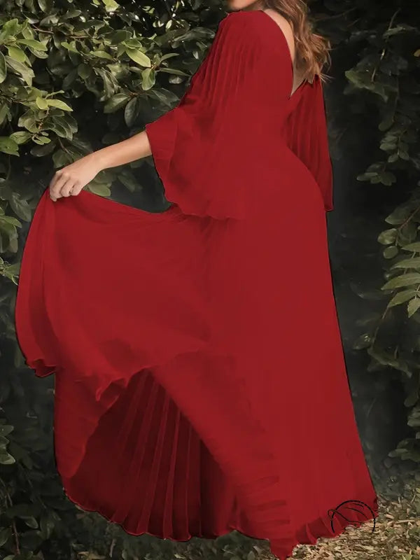 Gorgeous evening dress with flowing red maxi style and trumpet sleeves