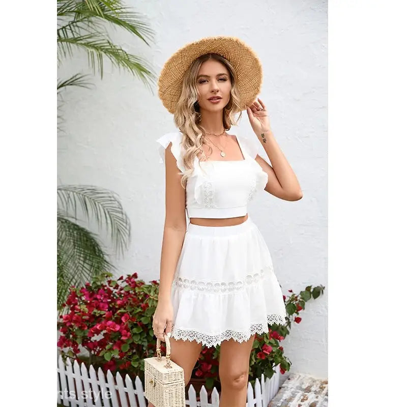 Woman in white skirt two piece suit with straw hat showcasing the Gorgeous Miami Set