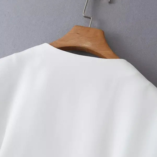 White garment on wooden hanger showcasing the gorgeous Yacht Fit Crop Top with high waist detail