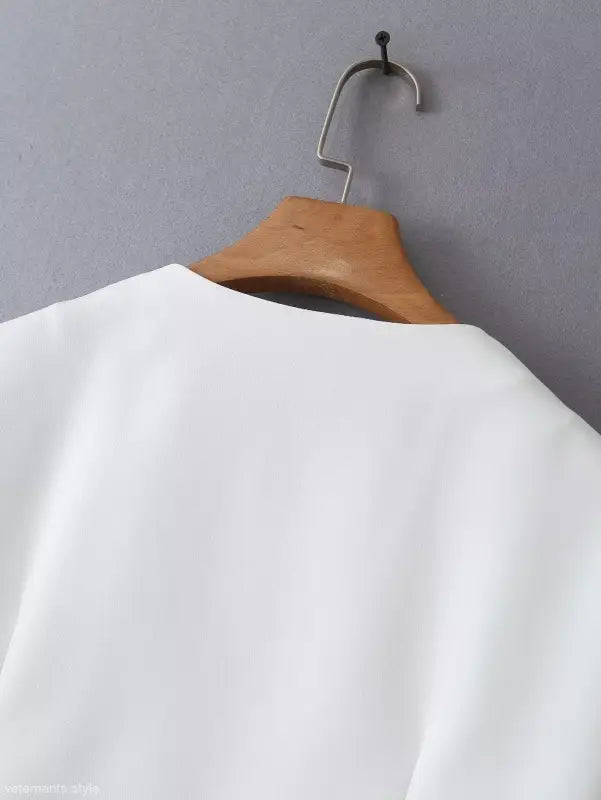White garment on wooden hanger showcasing the gorgeous Yacht Fit Crop Top with high waist detail