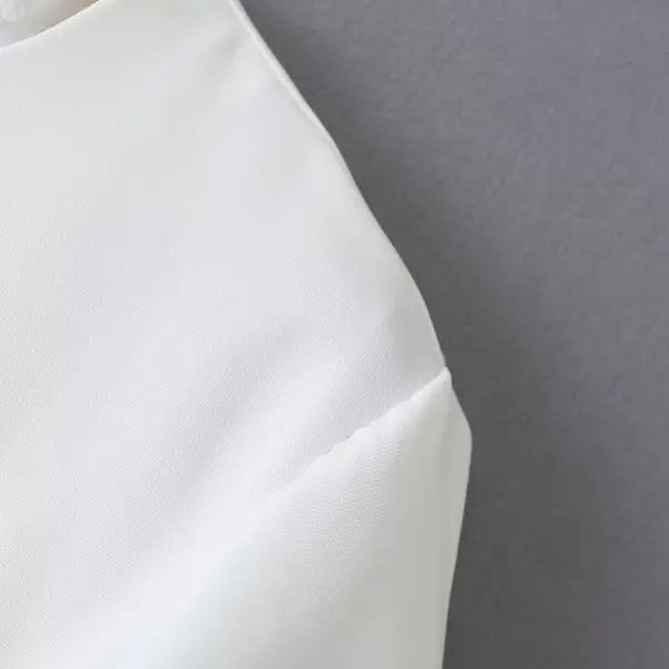 White fabric garment from the Gorgeous Yacht Fit Crop Top with Button and Pocket Detail collection