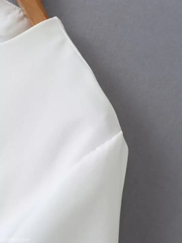 White fabric garment from the Gorgeous Yacht Fit Crop Top with Button and Pocket Detail collection