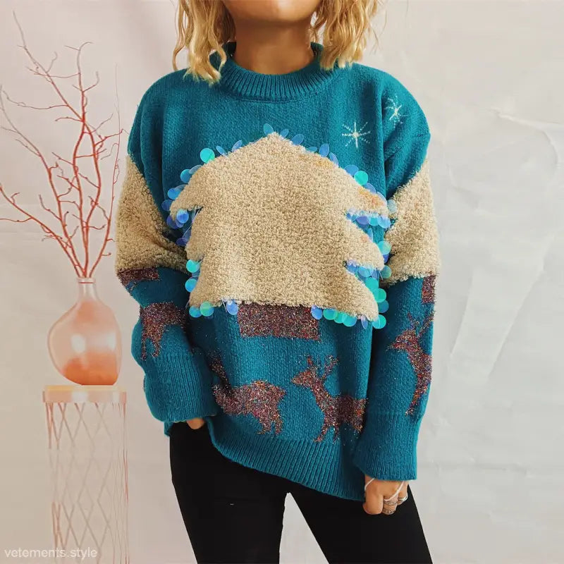 Teal handmade Christmas sweater with beige mountain design and blue pom-pom decorations