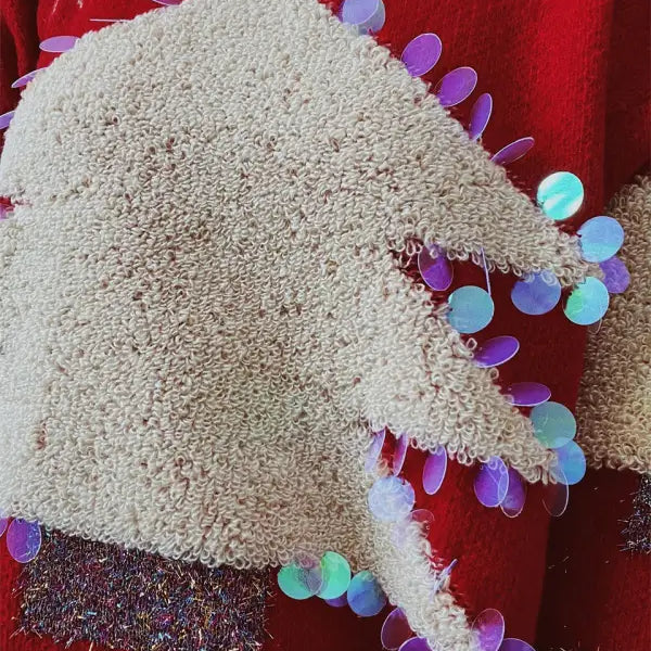Handmade Christmas sweater with colorful sequin details and fluffy white knit fabric